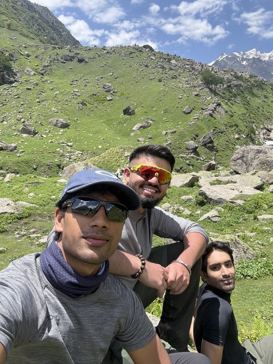 Three trekkers in sunglasses, the trail behind them
