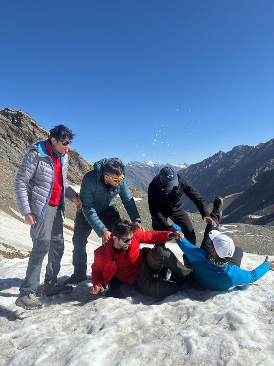 The five of them tumbling in the snow, one on his back, snow thrown into the air