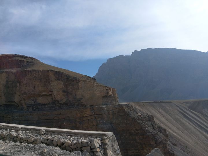 Layered brown cliffs and a bare mountain wall